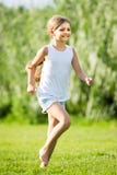 Muchacha que corre y que salta en hierba Fotos de archivo libres de regalías Muchacha que corre y que salta en hierba Fotos de archivo libres de regalías