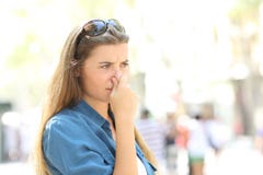 Muchacha que cubre su nariz debido al mún olor fotografía de archivo libre de regalías Muchacha que cubre su nariz debido al mún olor fotografía de archivo libre de regalías