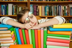 Muchacha que duerme en los libros en la biblioteca imagenes de archivo Muchacha que duerme en los libros en la biblioteca imagenes de archivo