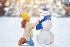 Muchacha que juega con un muñeco de nieve fotos de archivo Muchacha que juega con un muñeco de nieve fotos de archivo