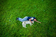 Muchacha que miente con su perrito en hierba verde fotografía de archivo libre de regalías Muchacha que miente con su perrito en hierba verde fotografía de archivo libre de regalías