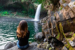 Muchacha que mira la cascada de Paix del La de Bassin en Reunion Island Foto de archivo libre de regalías Muchacha que mira la cascada de Paix del La de Bassin en Reunion Island Foto de archivo libre de regalías