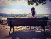 Muchacha que se relaja en un banco de parque Imagen de archivo libre de regalías Muchacha que se relaja en un banco de parque Imagen de archivo libre de regalías