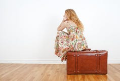 Muchacha que se sienta en una maleta de la vendimia, esperando foto de archivo libre de regalías Muchacha que se sienta en una maleta de la vendimia, esperando foto de archivo libre de regalías