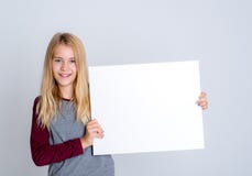 Muchacha rubia agradable que muestra una muestra blanca imágenes de archivo libres de regalías Muchacha rubia agradable que muestra una muestra blanca imágenes de archivo libres de regalías