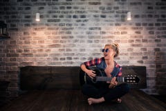 Muchacha rubia hermosa en la ropa causal que juega música en la guitarra imagenes de archivo Muchacha rubia hermosa en la ropa causal que juega música en la guitarra imagenes de archivo