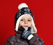 Muchacho del niño en sombrero hecho punto y suéter y manoplas que se divierten sobre fondo rojo colorido imagen de archivo libre de regalías Muchacho del niño en sombrero hecho punto y suéter y manoplas que se divierten sobre fondo rojo colorido imagen de archivo libre de regalías