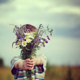 Muchacho del niño que sostiene el ramo de flores de los campos Niño que da las flores Imagen de archivo Muchacho del niño que sostiene el ramo de flores de los campos Niño que da las flores Imagen de archivo