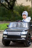 Muchacho lindo en montar un coche eléctrico negro en el parque fotos de archivo libres de regalías Muchacho lindo en montar un coche eléctrico negro en el parque fotos de archivo libres de regalías