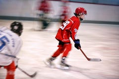 Muchacho que juega a hockey sobre hielo en la pista imagen de archivo Muchacho que juega a hockey sobre hielo en la pista imagen de archivo