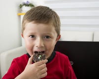 Muchacho que le ofrece una galleta del chocolate fotografía de archivo libre de regalías Muchacho que le ofrece una galleta del chocolate fotografía de archivo libre de regalías