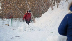 Muchacho y muchacha que juegan al aire libre en invierno Bolas de nieve del tiro de los niños almacen de metraje de vídeo Muchacho y muchacha que juegan al aire libre en invierno Bolas de nieve del tiro de los niños almacen de metraje de vídeo