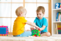 Muchachos del preescolar del niño de los niños que juegan el juguete lógico que aprende formas y colores en casa o cuarto de niño imagen de archivo libre de regalías Muchachos del preescolar del niño de los niños que juegan el juguete lógico que aprende formas y colores en casa o cuarto de niño imagen de archivo libre de regalías