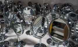 Muchos platean los espejos cosméticos con el marco redondo y escogen el soporte o foto de archivo libre de regalías Muchos platean los espejos cosméticos con el marco redondo y escogen el soporte o foto de archivo libre de regalías