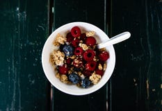 Muesli, дикие ягоды и завтрак йогурта на съемке белого шара верхней с черной деревянной предпосылкой стоковые фото Muesli, дикие ягоды и завтрак йогурта на съемке белого шара верхней с черной деревянной предпосылкой стоковые фото