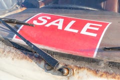 Muestra roja de la venta en el parabrisas sucio y viejo del coche usado, automóvil imagen de archivo Muestra roja de la venta en el parabrisas sucio y viejo del coche usado, automóvil imagen de archivo