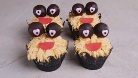 Muffin mit Schokoladenaugen und rotem Lächeln Ein grimmiger Minireaper, der eine Sense anhält, steht auf einem Kalendertag, der g stock footage Muffin mit Schokoladenaugen und rotem Lächeln Ein grimmiger Minireaper, der eine Sense anhält, steht auf einem Kalendertag, der g stock footage