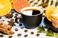 A mug of black coffee on a table with a cupcake napkin and cinnamon scattered coffee beans and sliced orange slices royalty free stock photos A mug of black coffee on a table with a cupcake napkin and cinnamon scattered coffee beans and sliced orange slices royalty free stock photos