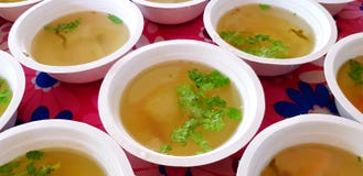 Muito sopa verde quente com as folhas cortadas do portal e da salsa ou do coentro na parte superior na bacia branca foto de stock Muito sopa verde quente com as folhas cortadas do portal e da salsa ou do coentro na parte superior na bacia branca foto de stock