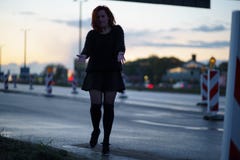 Mujer activa del bailar?n del viajero que se realiza en un sitio de la construcci?n de carreteras en el tiempo de la puesta del s imagenes de archivo Mujer activa del bailar?n del viajero que se realiza en un sitio de la construcci?n de carreteras en el tiempo de la puesta del s imagenes de archivo