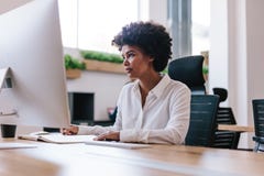 Mujer africana que trabaja en su escritorio de oficina imagen de archivo libre de regalías Mujer africana que trabaja en su escritorio de oficina imagen de archivo libre de regalías