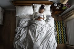 Mujer afroamericana en dormir de la cama imágenes de archivo libres de regalías Mujer afroamericana en dormir de la cama imágenes de archivo libres de regalías