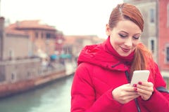 Mujer alegre que usa el teléfono en la calle fotografía de archivo Mujer alegre que usa el teléfono en la calle fotografía de archivo
