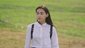Mujer asiática bonita que va en el claro en la cámara lenta y persona que endereza el pelo almacen de metraje de vídeo Mujer asiática bonita que va en el claro en la cámara lenta y persona que endereza el pelo almacen de metraje de vídeo