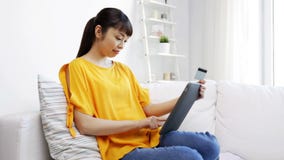 Mujer asiática feliz con PC de la tableta y la tarjeta de crédito almacen de metraje de vídeo Mujer asiática feliz con PC de la tableta y la tarjeta de crédito almacen de metraje de vídeo