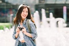 Mujer asiática hermosa joven del viajero de la mochila que usa la cámara compacta digital y la sonrisa, mirando el espacio de la imágenes de archivo libres de regalías Mujer asiática hermosa joven del viajero de la mochila que usa la cámara compacta digital y la sonrisa, mirando el espacio de la imágenes de archivo libres de regalías