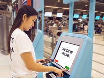Mujer asiática joven con el pasaporte usando uno mismo - regístrese el tacto del quiosco imágenes de archivo libres de regalías Mujer asiática joven con el pasaporte usando uno mismo - regístrese el tacto del quiosco imágenes de archivo libres de regalías