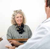 Mujer asustada preocupante que habla con su doctor foto de archivo libre de regalías Mujer asustada preocupante que habla con su doctor foto de archivo libre de regalías