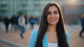 Mujer atractiva que liga en una c?mara que camina en cuadrado de ciudad almacen de video Mujer atractiva que liga en una c?mara que camina en cuadrado de ciudad almacen de video