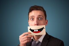 Mujer bonita feliz que sostiene la tarjeta con smiley divertido imagen de archivo Mujer bonita feliz que sostiene la tarjeta con smiley divertido imagen de archivo