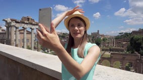 Mujer cerca del foro Romanum que hace el selfie en el teléfono móvil Foto que toma turística contra el foro romano metrajes Mujer cerca del foro Romanum que hace el selfie en el teléfono móvil Foto que toma turística contra el foro romano metrajes
