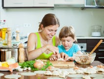 Mujer con el niño que cocina el pelmeni de los pescados (pelmeni), siempre junto fotos de archivo libres de regalías Mujer con el niño que cocina el pelmeni de los pescados (pelmeni), siempre junto fotos de archivo libres de regalías