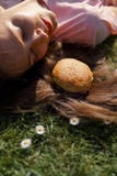 Mujer de negocios acertada que miente en la hierba con el cheesburger de la hamburguesa de los alimentos de preparaci?n r?pida en imagen de archivo libre de regalías Mujer de negocios acertada que miente en la hierba con el cheesburger de la hamburguesa de los alimentos de preparaci?n r?pida en imagen de archivo libre de regalías
