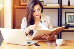 Mujer de negocios asiática joven que trabaja en el lugar de trabajo imagen de archivo Mujer de negocios asiática joven que trabaja en el lugar de trabajo imagen de archivo
