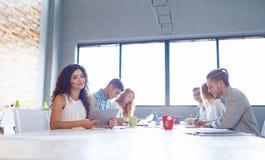 Mujer de negocios atractiva en la reunión con los colegas en el fondo de la oficina Concepto de la reunión de la oficina foto de archivo libre de regalías Mujer de negocios atractiva en la reunión con los colegas en el fondo de la oficina Concepto de la reunión de la oficina foto de archivo libre de regalías