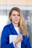Mujer de negocios elegante joven en tableta de la tenencia de la chaqueta azul fotografía de archivo Mujer de negocios elegante joven en tableta de la tenencia de la chaqueta azul fotografía de archivo