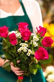 Mujer del florista que lleva a cabo las manos del ramo de las rosas rojas fotos de archivo Mujer del florista que lleva a cabo las manos del ramo de las rosas rojas fotos de archivo