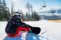Mujer del Snowboarder que descansa sobre cuesta del esquí bajo elevación imagen de archivo libre de regalías Mujer del Snowboarder que descansa sobre cuesta del esquí bajo elevación imagen de archivo libre de regalías