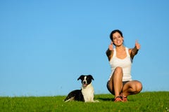 Mujer deportiva acertada que toma un resto de ejercicio con su perro imagen de archivo Mujer deportiva acertada que toma un resto de ejercicio con su perro imagen de archivo