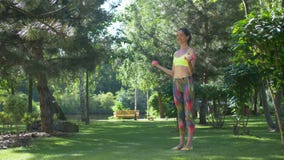 Mujer deportiva con las pesas de gimnasia que doblan los músculos al aire libre metrajes Mujer deportiva con las pesas de gimnasia que doblan los músculos al aire libre metrajes