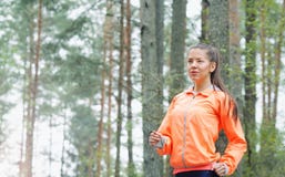 Mujer deportiva de la forma de vida sana que corre temprano por la mañana en f imagenes de archivo Mujer deportiva de la forma de vida sana que corre temprano por la mañana en f imagenes de archivo