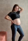 Mujer embarazada de los j?venes Mujer hermosa embarazada que presenta en casa fotos de archivo Mujer embarazada de los j?venes Mujer hermosa embarazada que presenta en casa fotos de archivo