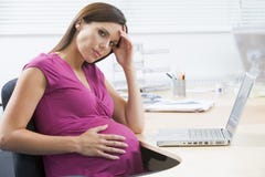 Mujer embarazada en el trabajo que parece tensionado foto de archivo Mujer embarazada en el trabajo que parece tensionado foto de archivo