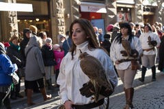 Mujer en el traje medieval que sostiene un halcón en el desfile tradicional del festival medieval de Befana de la epifanía en Flo imagen de archivo Mujer en el traje medieval que sostiene un halcón en el desfile tradicional del festival medieval de Befana de la epifanía en Flo imagen de archivo