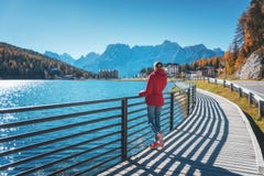 Mujer en la costa del lago Misurina en la salida del sol en otoño fotos de archivo libres de regalías Mujer en la costa del lago Misurina en la salida del sol en otoño fotos de archivo libres de regalías