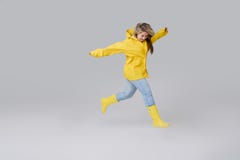 Mujer en un impermeable amarillo en un fondo gris imagen de archivo libre de regalías Mujer en un impermeable amarillo en un fondo gris imagen de archivo libre de regalías